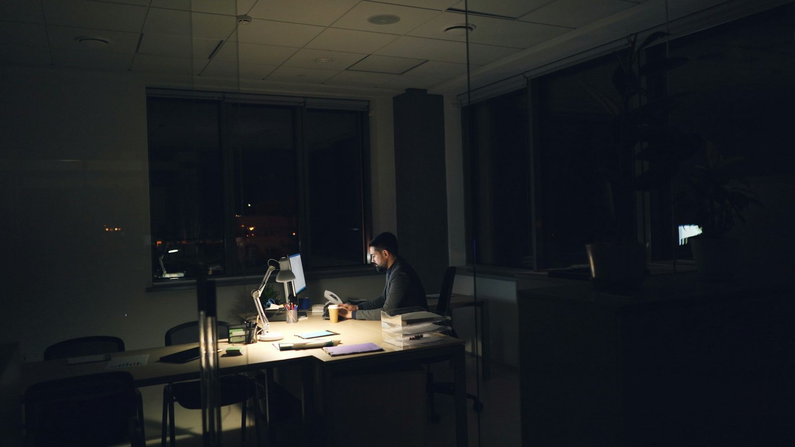 Business owner working late at a dimly lit office desk
